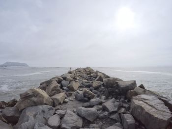 Rocks by sea against sky