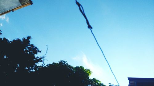 Low angle view of power lines against blue sky