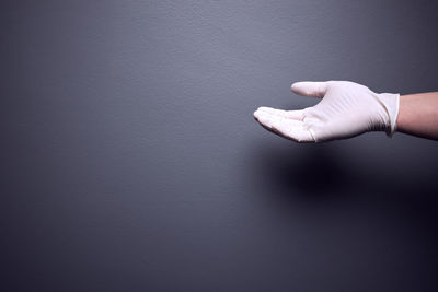 Close-up of human hand against wall