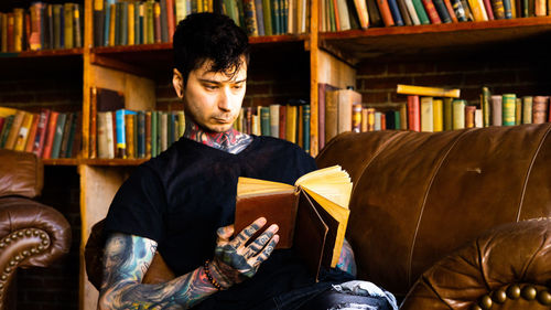 Portrait of young man sitting in library