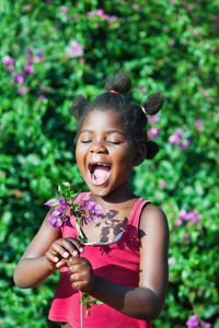 Portrait of a smiling girl standing against plants