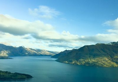 Scenic view of sea and mountains against sky