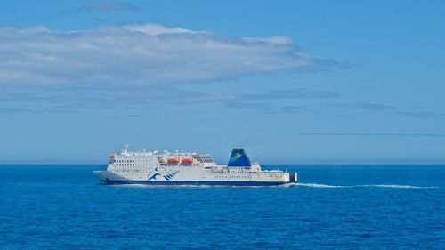 Ship sailing on sea against sky