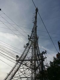 Low angle view of power lines against cloudy sky