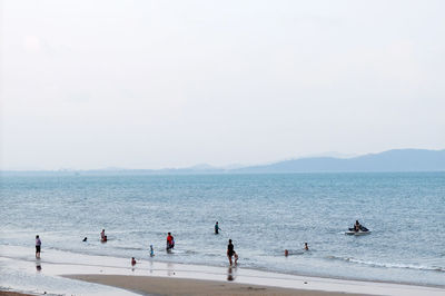 People on beach against clear sky