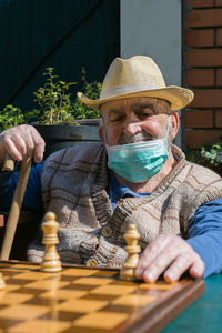 Senior man playing chess in yard