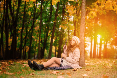 Young woman using mobile phone while sitting in park