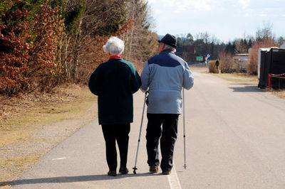 Rear view of people walking on road