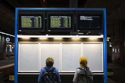 Women looking at departure board at train station
