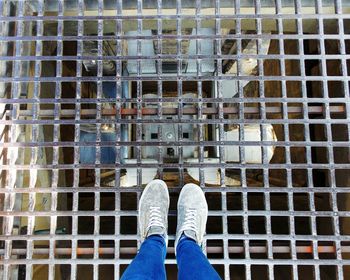 Low section of man standing on tiled floor