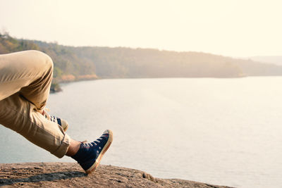 Close-up of man's legs against clear sky