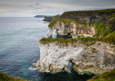 Scenic view of rock formation in sea against sky