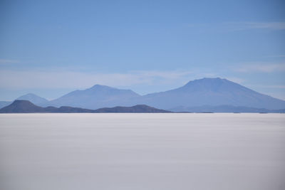 Scenic view of mountains against blue sky