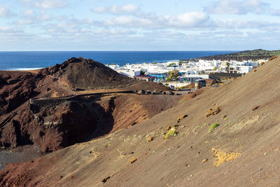 Scenic view of beach by buildings against sky