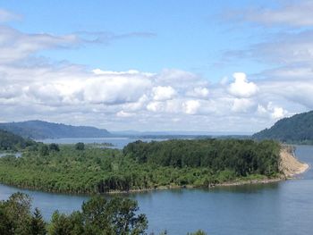 Scenic view of river and mountains against sky