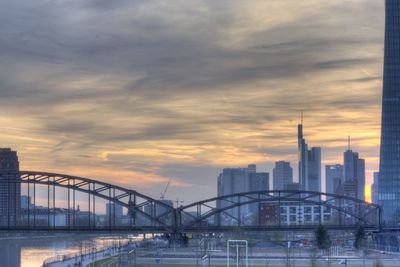 Cityscape against cloudy sky at sunset