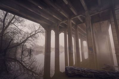 Bridge on calm lake in foggy weather