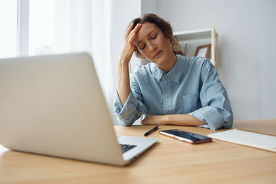 Businesswoman using laptop at desk in office