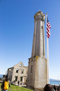 Low angle view of flags against clear blue sky