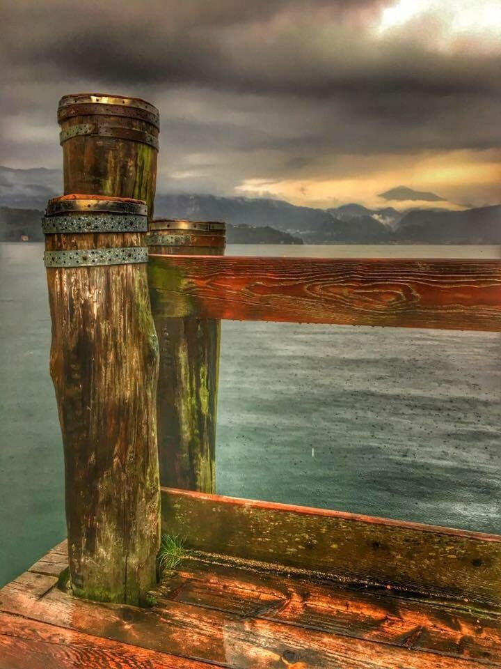 WOODEN POSTS ON BEACH AGAINST SKY