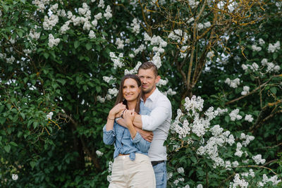 Beautiful young couple in a romantic place, spring blooming lilac garden. happy joyful couple 