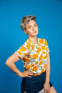 Portrait of teenage girl against blue background