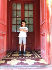 Portrait of boy smiling while standing at entrance