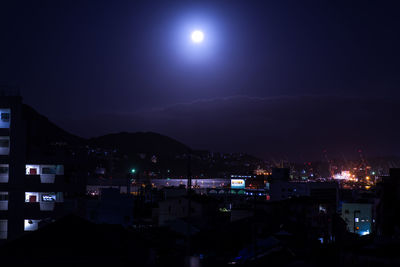 Illuminated buildings in city against sky at night