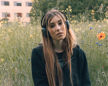 Portrait of young woman standing on field