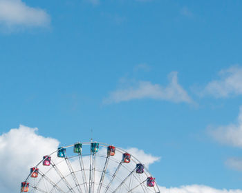 Low angle view of ferris wheel against blue sky