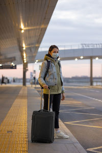 Woman standing at airport against sky