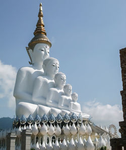 Low angle view of buddha statue against sky