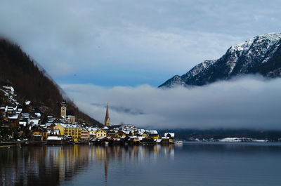 Scenic view of river and mountains against cloudy sky