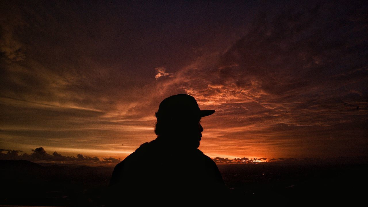 SILHOUETTE MAN STANDING AGAINST SKY AT SUNSET