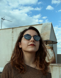 Close-up of young woman wearing sunglasses against sky