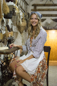 Portrait of smiling young woman sitting on chair