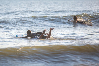 People paddling on surfboards in sea