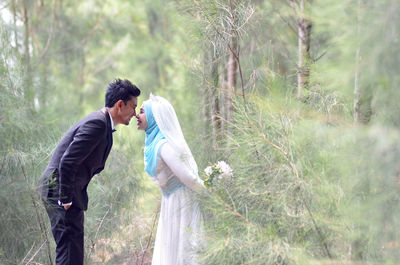 Side view of young couple standing on land