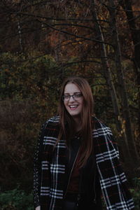 Portrait of smiling young woman wearing scarf during sunset
