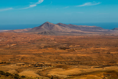 Scenic view of desert against blue sky