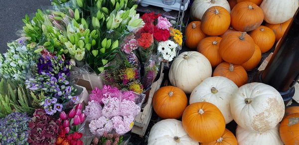 High angle view of pumpkins and flowers for sale at market stall