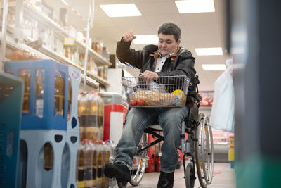 A disabled person in a wheelchair buys groceries