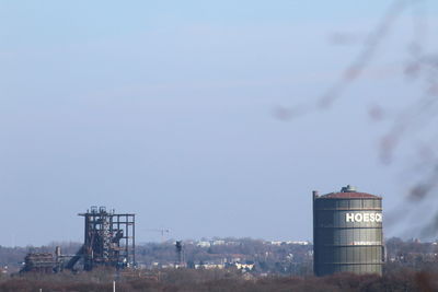 Factory on field against sky