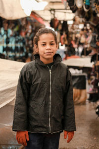 Portrait of young woman standing in city