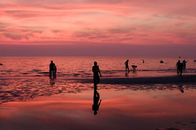 Silhouette people at beach during sunset