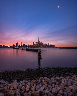 View of buildings at waterfront during sunset