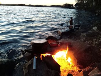 Bonfire on wooden log in lake