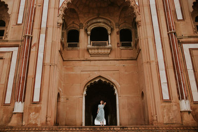 From below full body of female traveler standing against archway of safdarjungs tomb historic landmark of new delhi