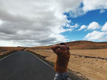 Man standing on empty road against sky