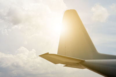 Low angle view of airplane flying against sky on sunny day